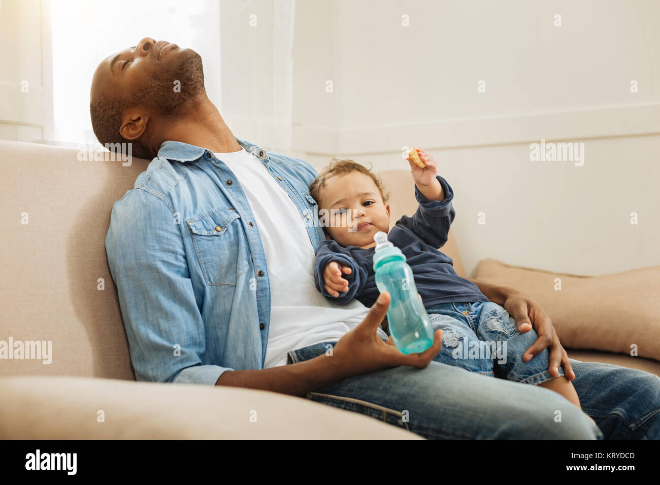 Sleeping uomo con il suo figlio e il suo flacone Foto Stock