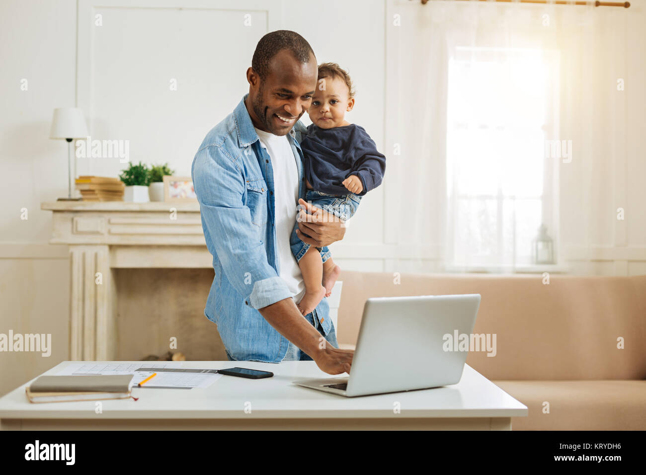 Papà sorridente tenendo il suo figlio e la digitazione Foto Stock
