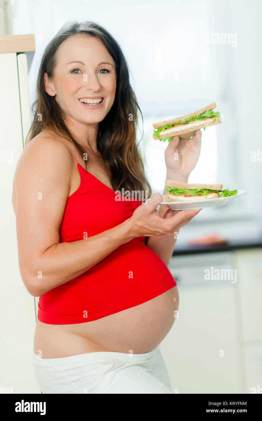 Schwangere Frau isst ein panino - donna incinta mangia un sandwich Foto Stock