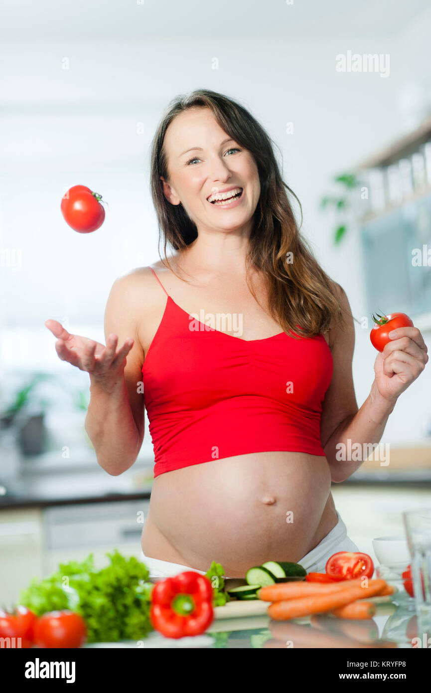 Schwangere Frau beim Kochen - donna incinta per la cottura Foto Stock