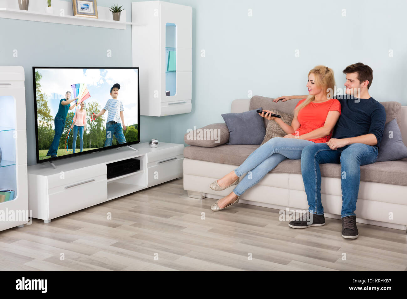 Giovane guardando film in televisione a casa Foto Stock