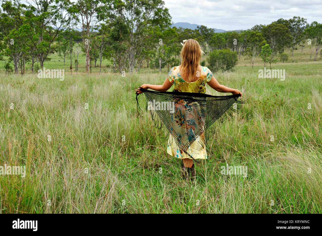 Giovane donna camminare in un campo Foto Stock