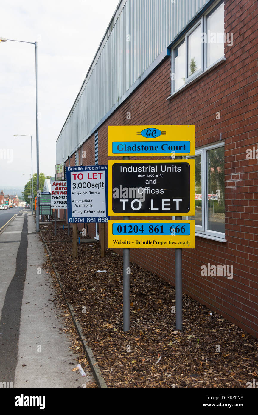 Cartelli posti dal Brindle Properties Advertising unità industriali e uffici per consentire alla Corte di Gladstone, Farnworth, Greater Manchester. Foto Stock
