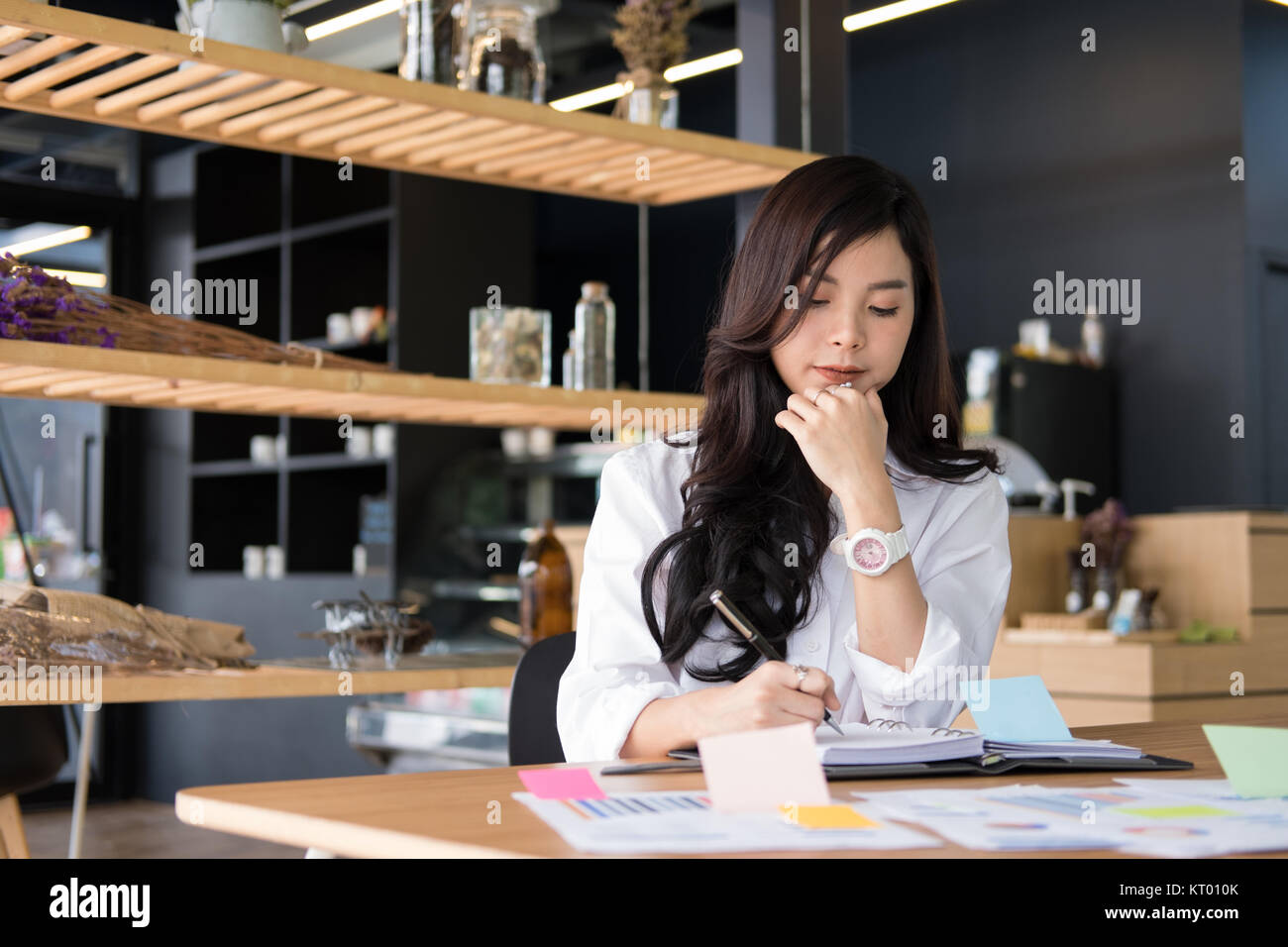 Asian imprenditrice scrivi nota sul notebook a workplace. startup donna lavora con il business plan documento relazione presso l'ufficio. giovani femmine entrepreneu Foto Stock