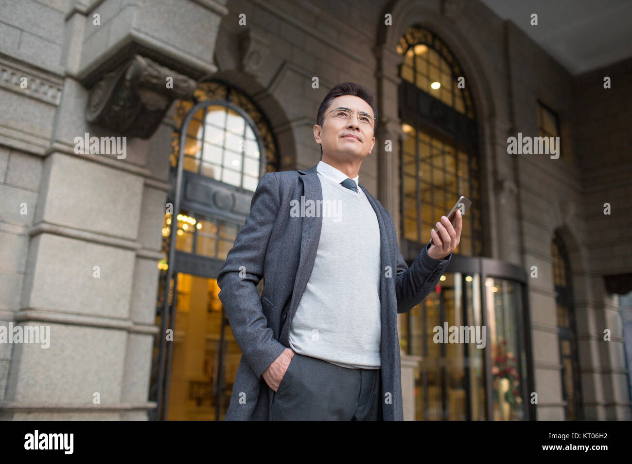 Fiducioso imprenditore tenendo un telefono intelligente Foto Stock