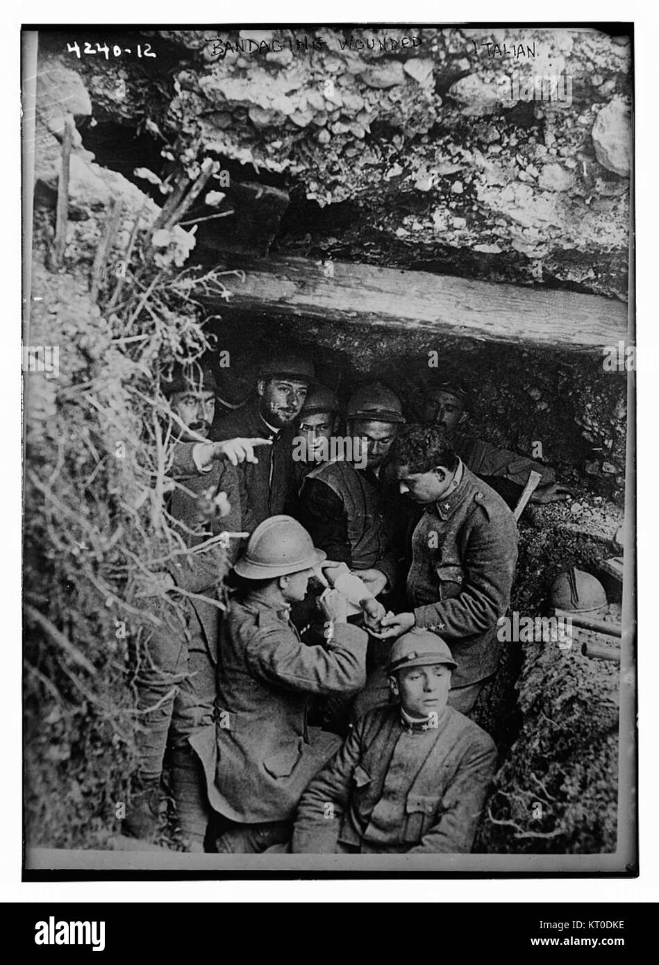 Questa immagine probabilmente raffigura la pratica di bendare i feriti, un aspetto chiave del pronto soccorso e delle cure mediche durante i conflitti o le emergenze. Il numero di riferimento (19305681996) può essere associato a un evento storico specifico o a una pratica medica. Foto Stock