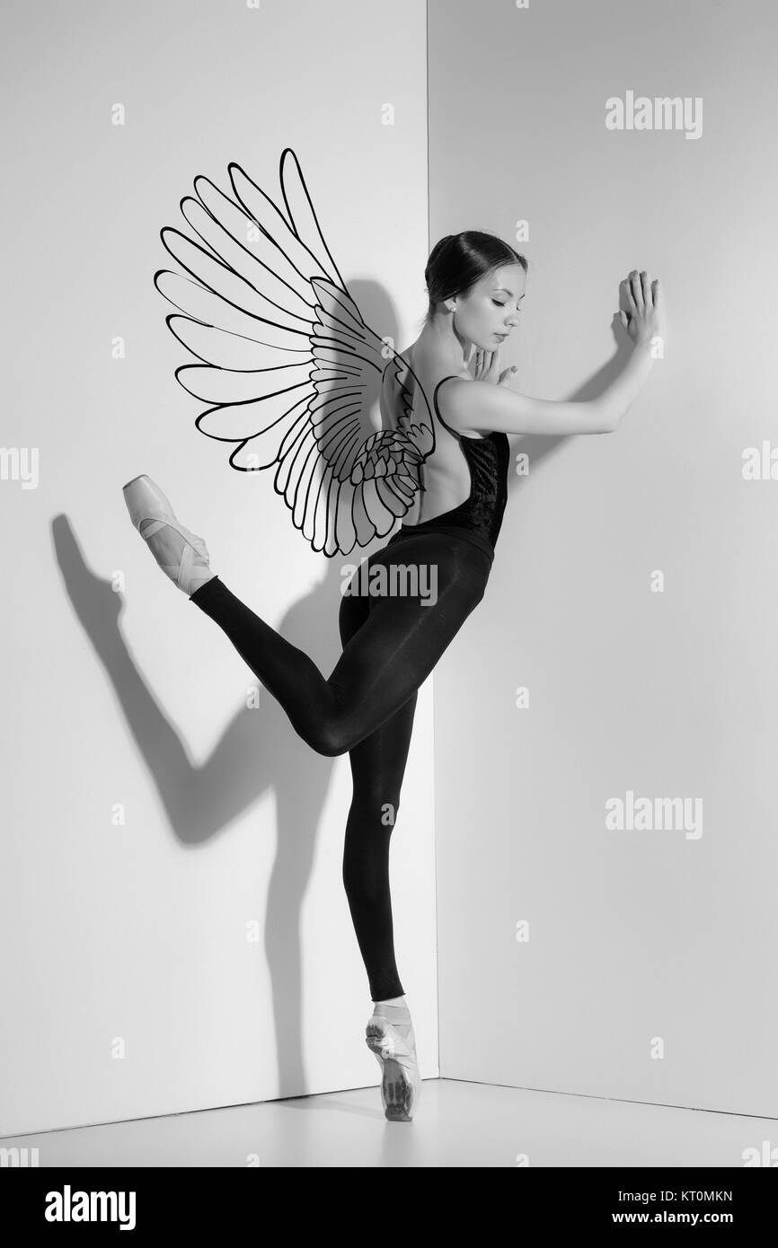Ballerina in abito nero in posa sul pointe scarpe, di sfondo per studio. Foto Stock