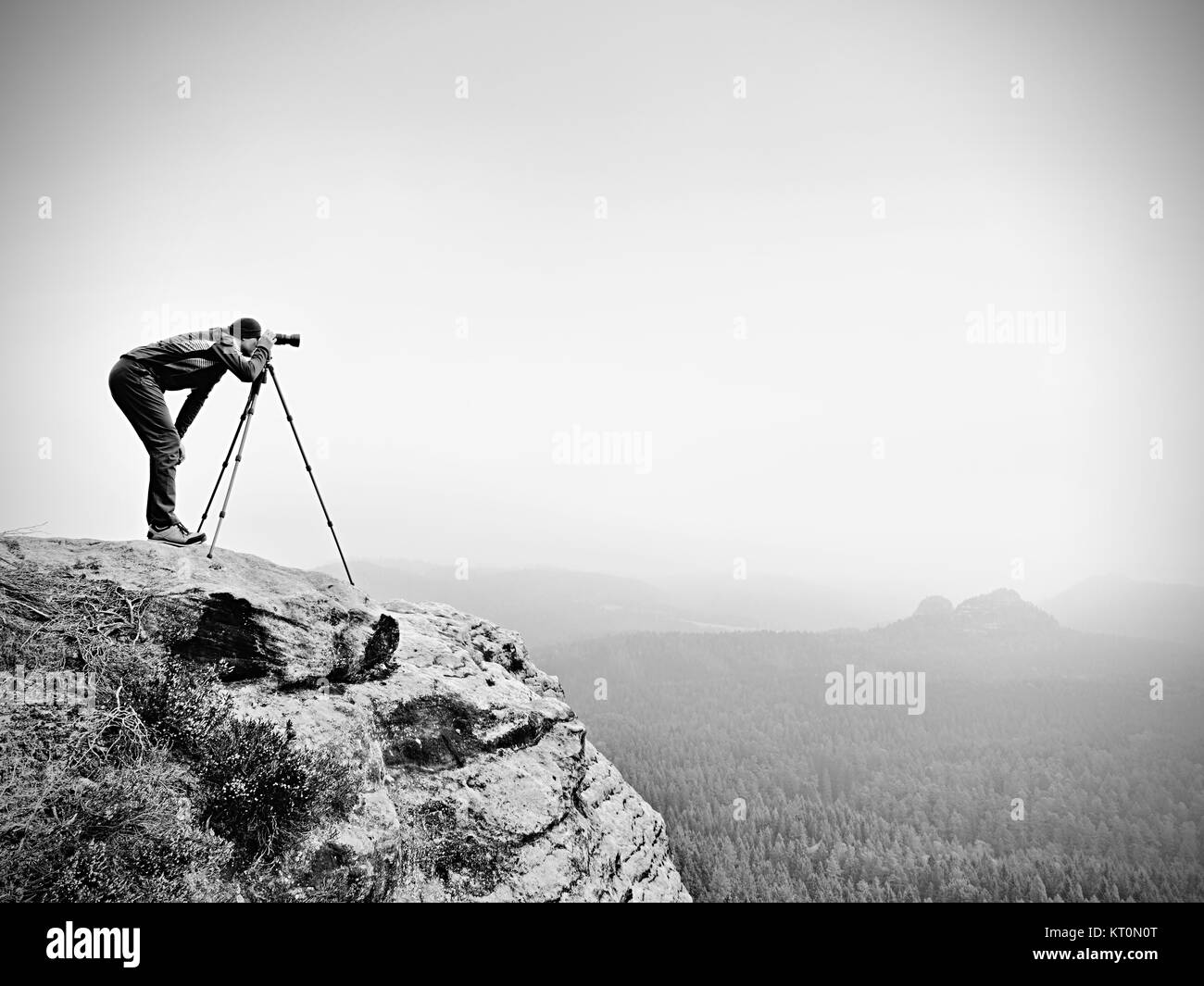 Wildlife Photographer sul vertice di montagna opere. Uomo come per i viaggi e la fotografia, scattare foto di momenti durante il tramonto autunnale in orizzontale Foto Stock