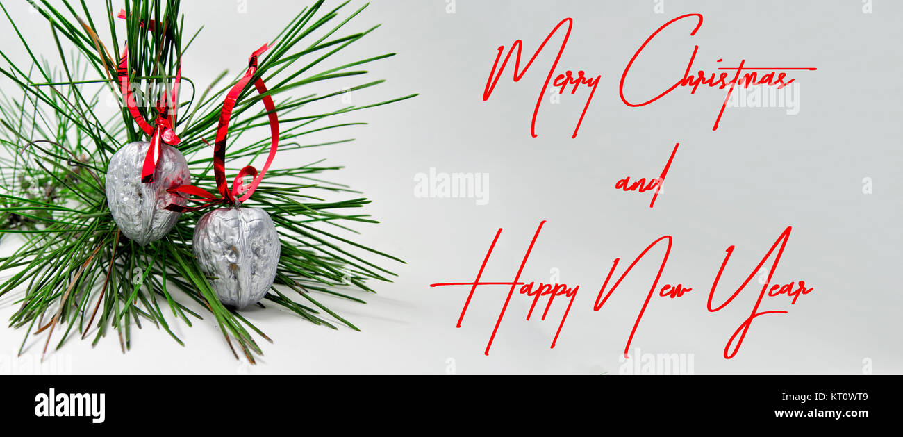 Buon Natale e Felice Anno Nuovo decorazione con una verde ramo di pino e i dadi in argento con Red Ribbon. Per auguri card concept Foto Stock