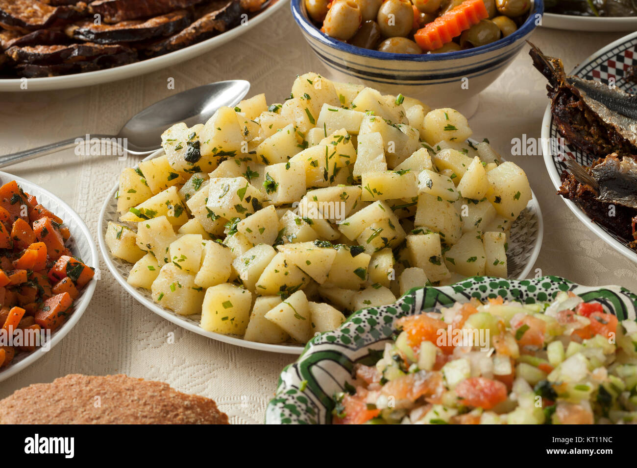 Pasto marocchino con una varietà di piatti con prodotti freschi cotti di sardine, verdura e pane Foto Stock