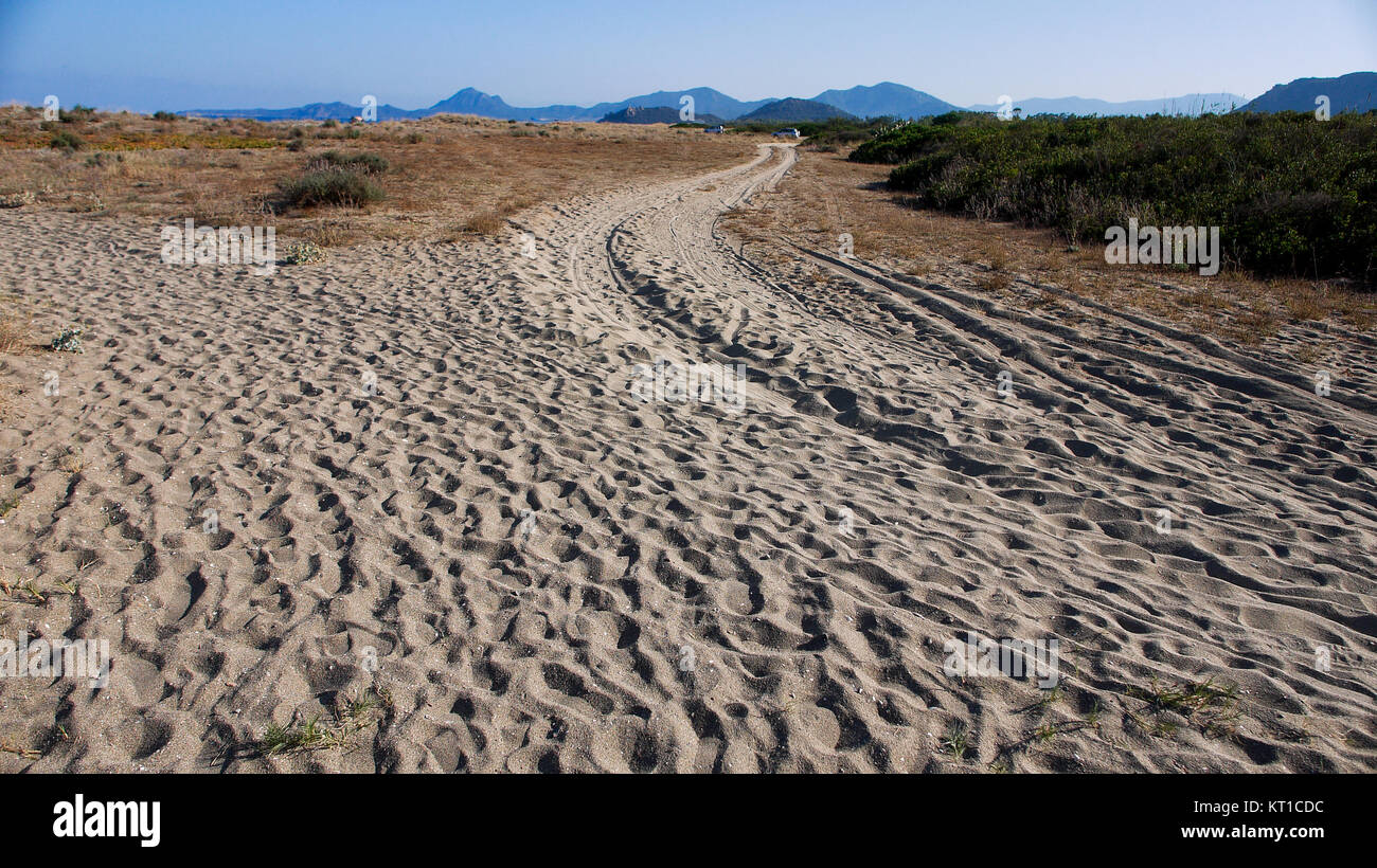 Footprint e auto via su una spiaggia di sabbia bianca, Muraverq district, Sardegna, Italia Foto Stock
