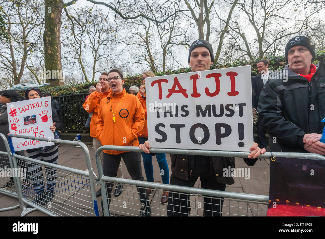 Mondo Animale elementi di protezione in arancione ee manifestanti con manifesti presso l'Ambasciata giapponese a Londra chiamata per porre fine alla brutale massacro di delfini nel Taiji Cove in Giappone. Foto Stock