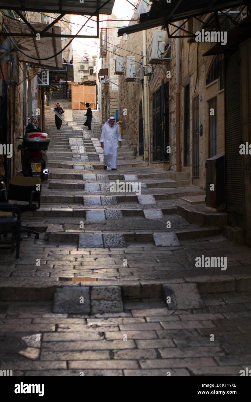 Musulmani locali e gli ebrei a piedi verso il basso antica street nella Città Vecchia di Gerusalemme. Foto Stock