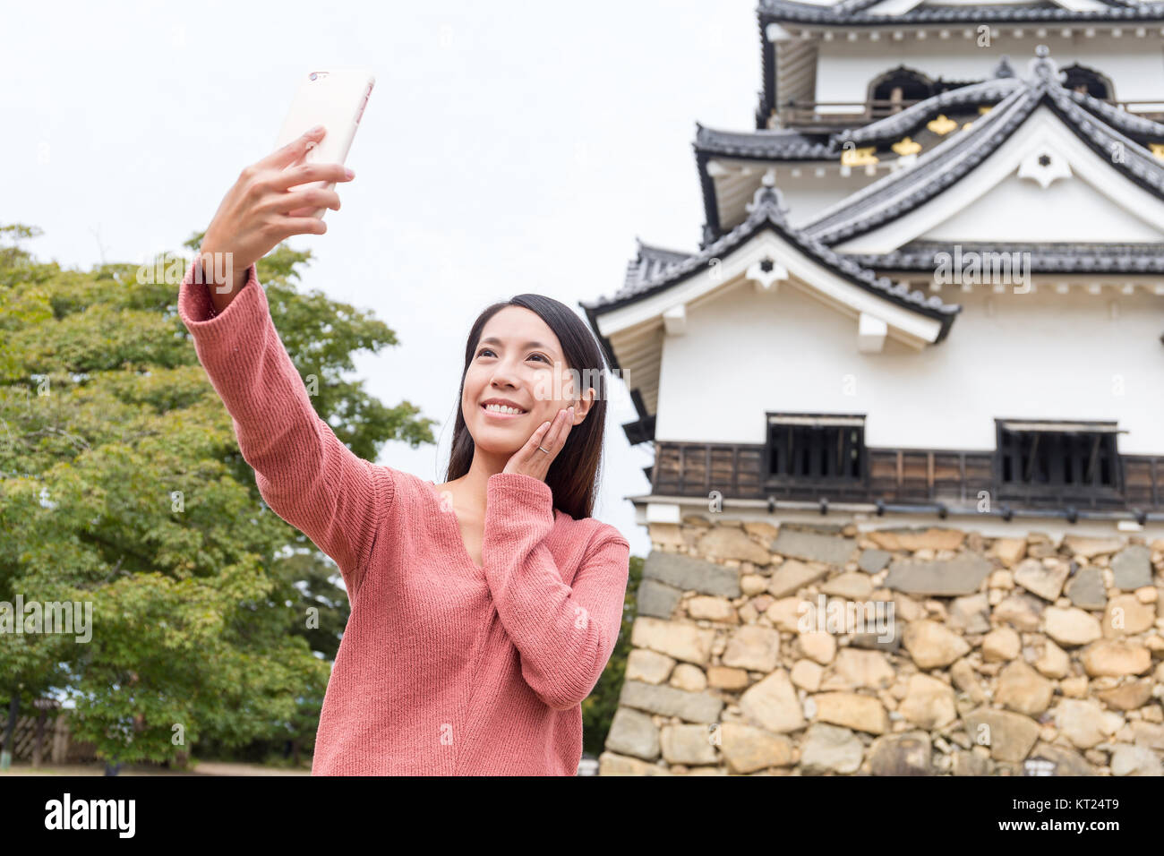 Donna prendendo selfie dal telefono mobile nel castello di Hikone Foto Stock