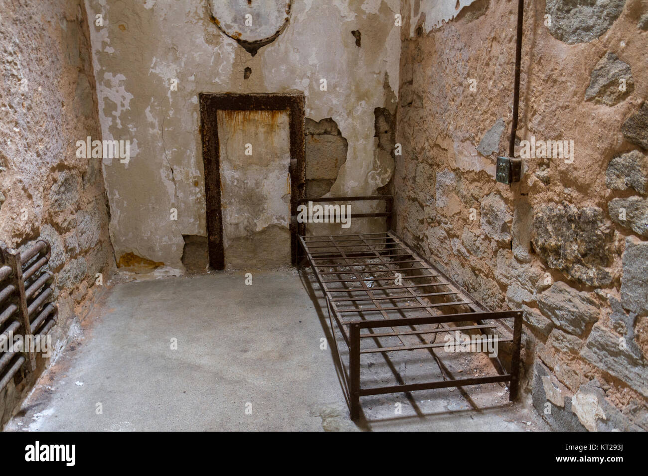 La tipica cella con letto abbandonato il telaio nella parte orientale di Stato penitenziario sito storico, Philadelphia, Stati Uniti. Foto Stock