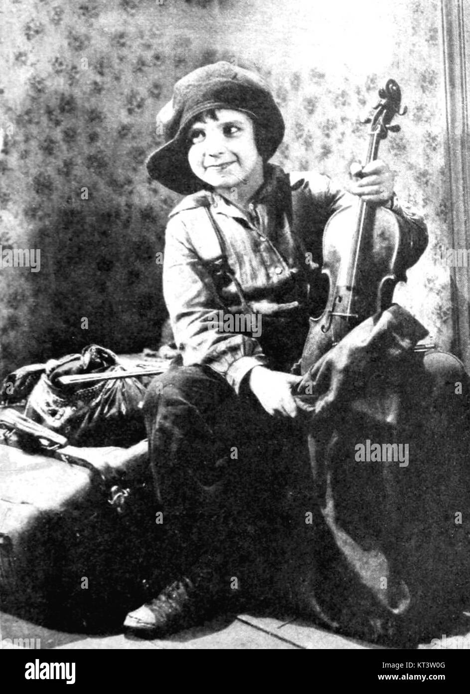 Un'immagine storica di un uomo, chiamato Jackie, con il suo vecchio violino. La foto cattura il significato della musica e il suo legame culturale con l'individuo e il suo patrimonio culturale. Foto Stock