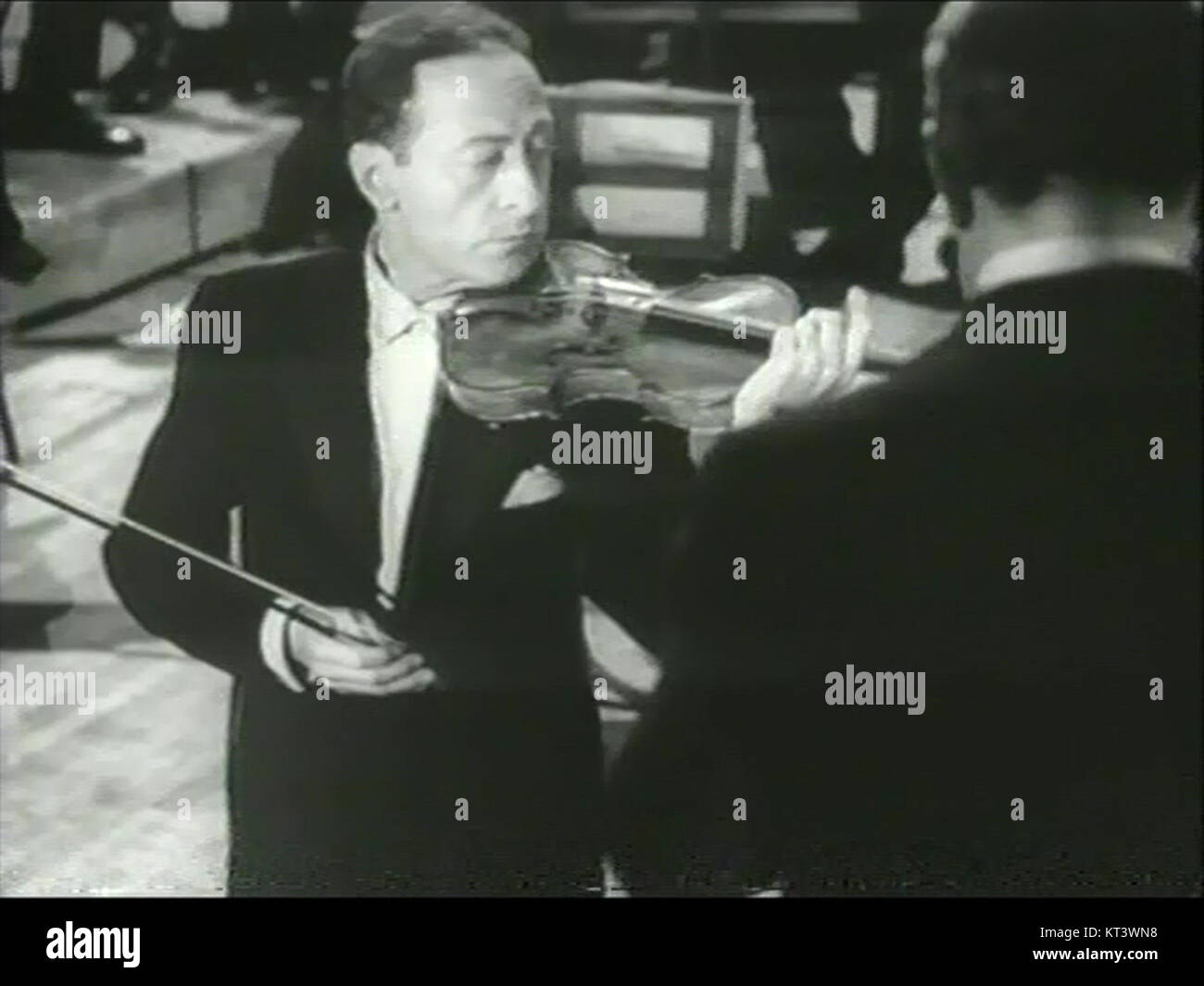 Questa immagine mostra il famoso violinista Jascha Heifetz che si esibisce alla Carnegie Hall nel 1947. Heifetz, noto per la sua maestria tecnica e le sue esibizioni espressive, fu uno dei più grandi violinisti del XX secolo. Foto Stock