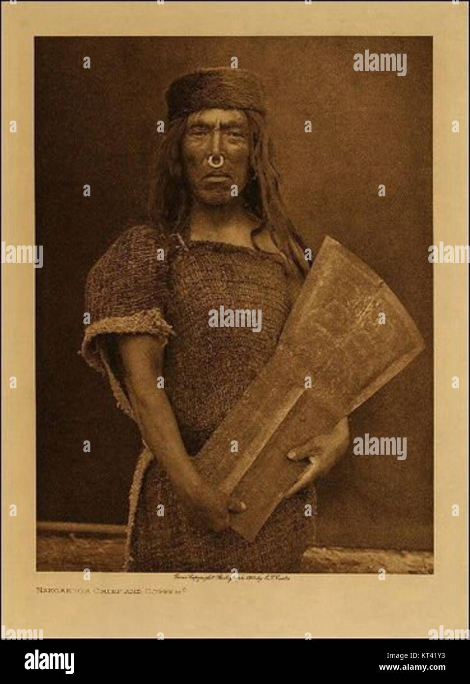 Questa iconica fotografia di Edward Curtis mostra un uomo Kwakwaka'wakw con uno scudo di rame, un importante oggetto culturale nell'arte dei nativi americani, che simboleggia il patrimonio e la tradizione. Foto Stock