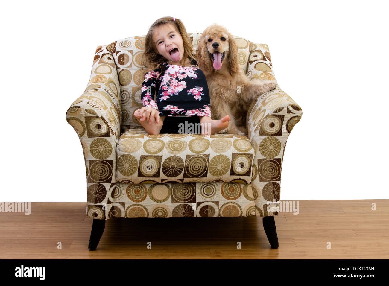 Giovane ragazza e il suo cucciolo di rilassarsi in una poltrona insieme sia spuntavano le loro lingue come ella imita il cane ansimante Foto Stock