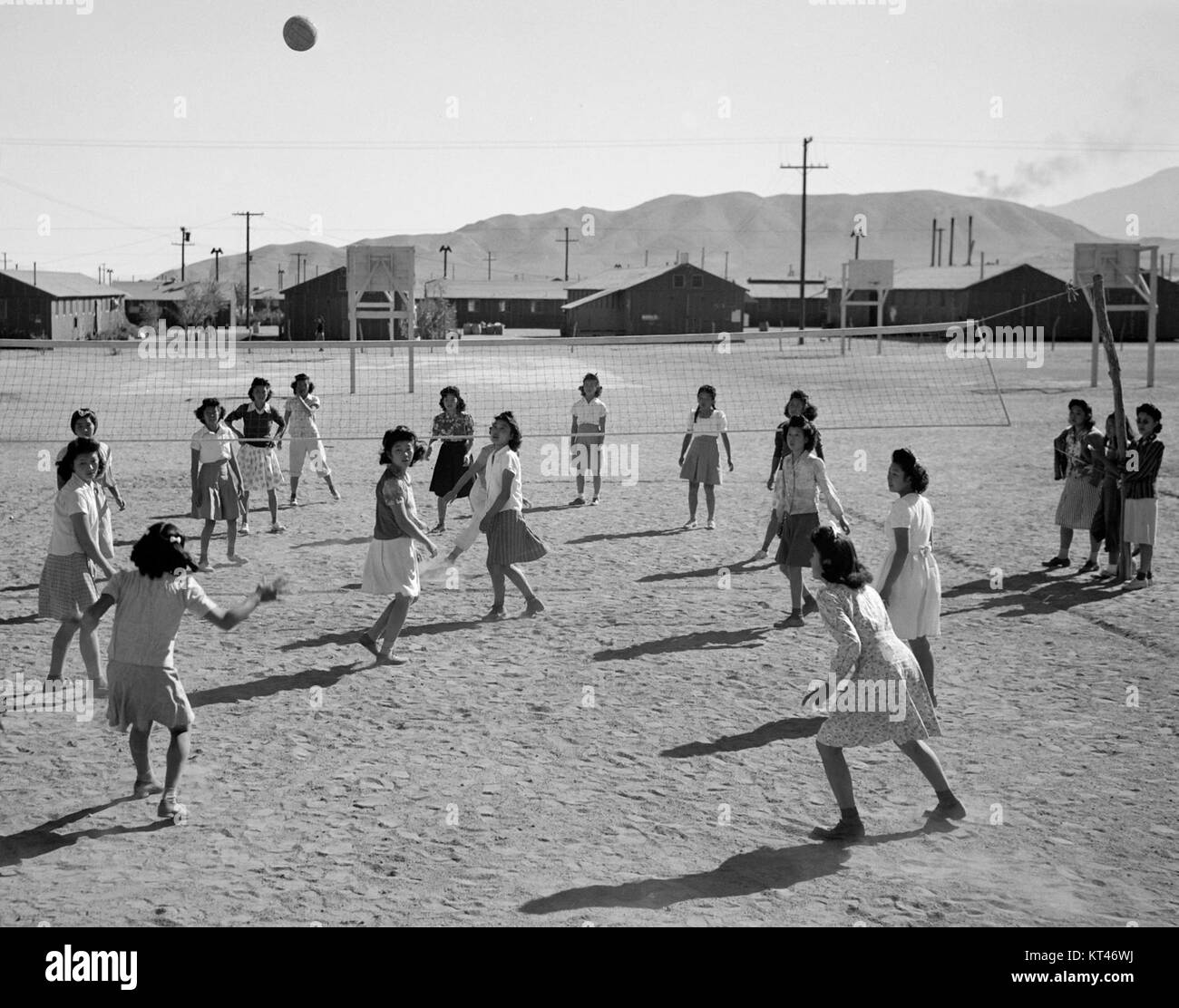 La foto cattura una partita di pallavolo al Manzanar War Relocation Center, un campo di internamento giapponese-americano durante la seconda guerra mondiale. Il gioco è una rappresentazione della vita quotidiana e della resilienza degli internati. Foto Stock