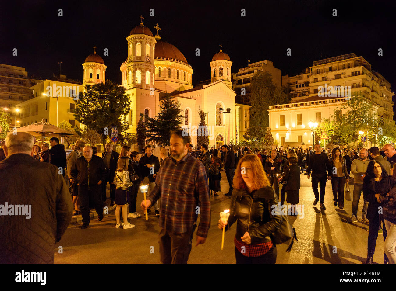 I cristiani ortodossi nella Santa Notte di venerdì, passeggiate intorno alla chiesa e tenendo acceso candele, Salonicco, Grecia Foto Stock