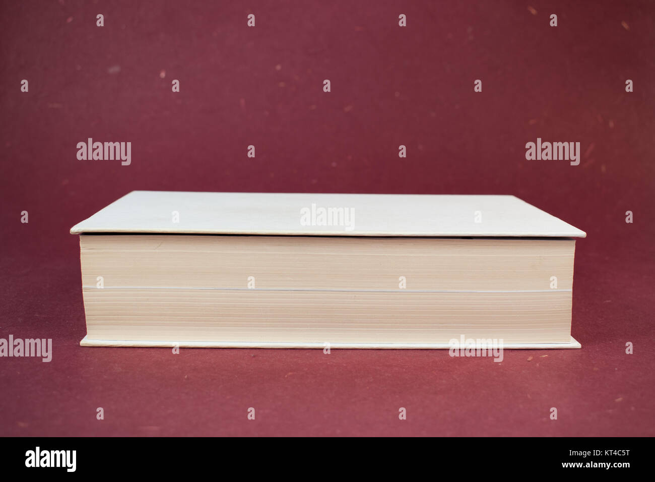 Vuoto bianco libro rilegato su sfondo rosso Foto Stock