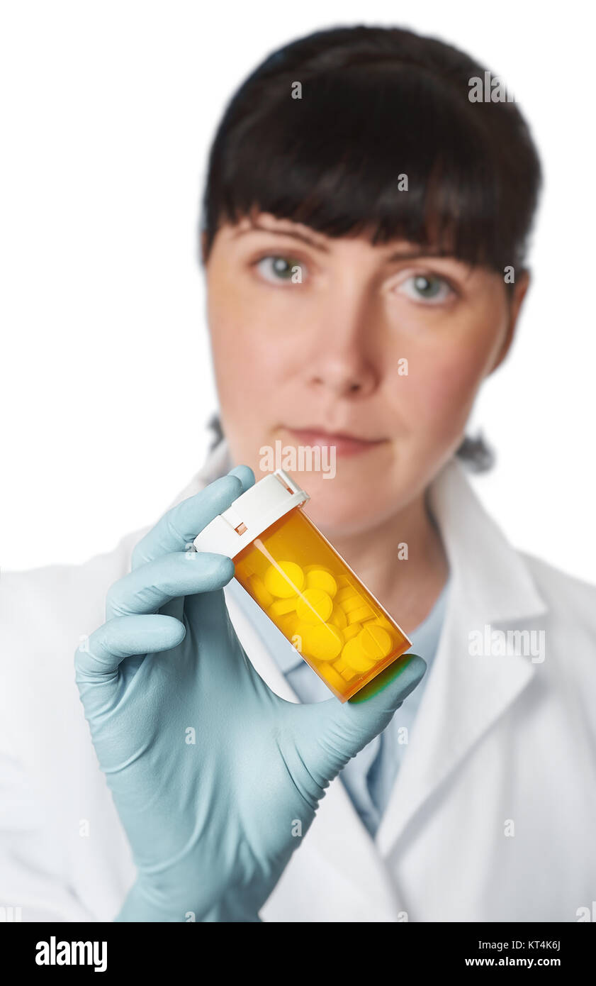 Donne medico o infermiere con il giallo un vasetto di pillole in mano su sfondo bianco. DOF poco profondo, concentrarsi sulle pillole Foto Stock