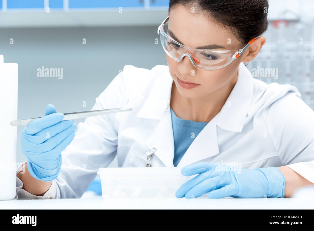 Ritratto di uno scienziato concentrato in occhiali di protezione e guanti rendendo esperimento Foto Stock