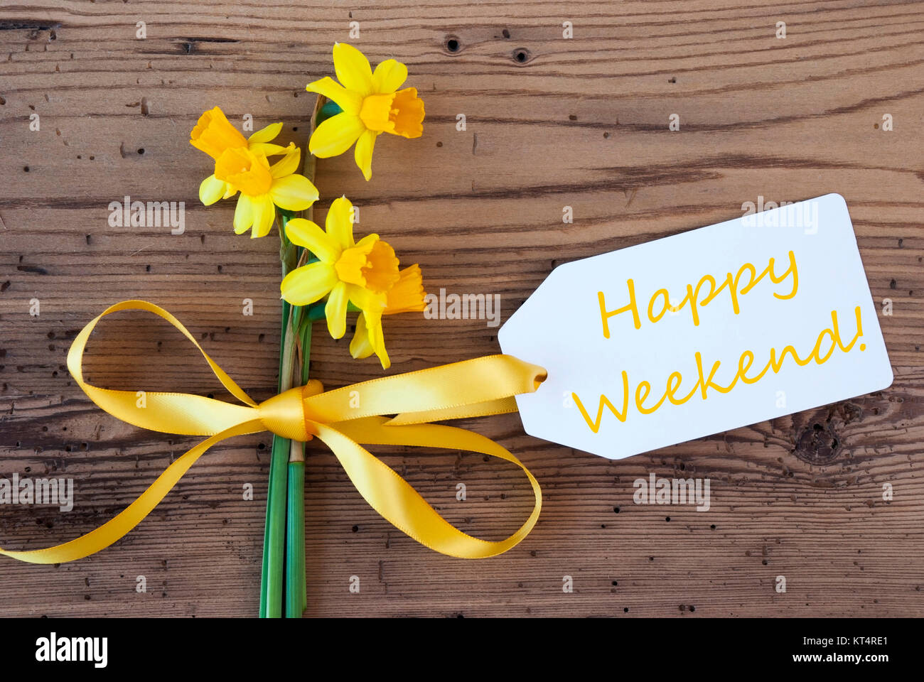 Etichetta con testo in inglese Happy Weekend. Molla gialla Narciso o Daffodil con nastro. Invecchiato, botte rustico sfondo. Biglietto di auguri per la stagione primavera Foto Stock