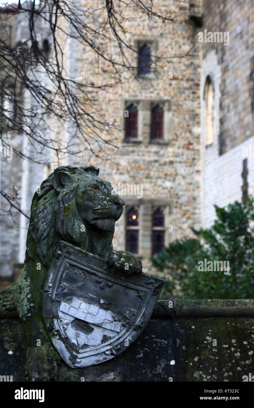 La scultura in pietra di Lion con protezione sulla parete animale, Castello di Cardiff in background, Cardiff, South Glamorgan, Wales, Regno Unito Foto Stock