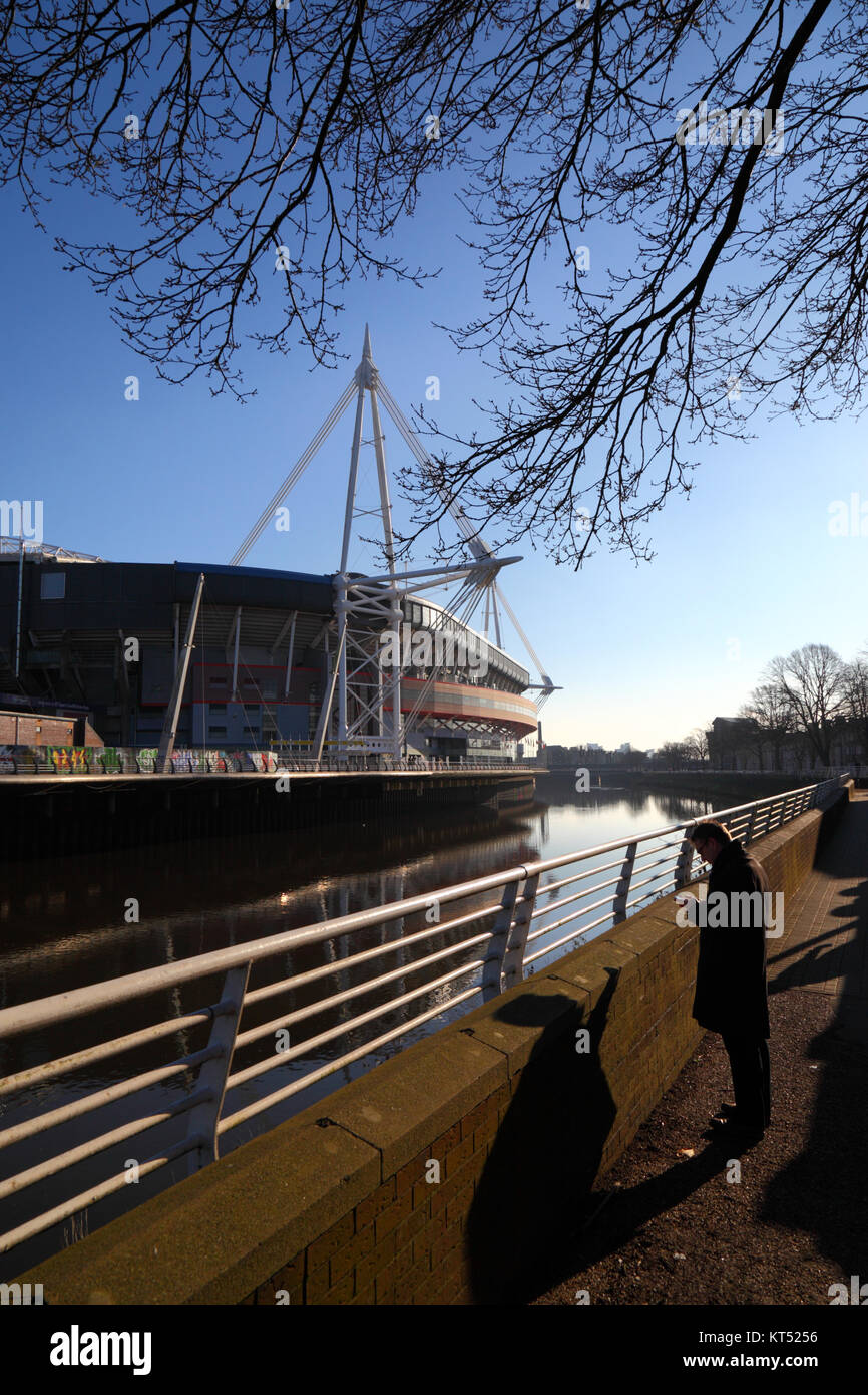 Vista del millennio / Principato Stadium, fiume Taff, Cardiff e uomo utilizza lo smartphone, South Glamorgan, Wales, Regno Unito Foto Stock