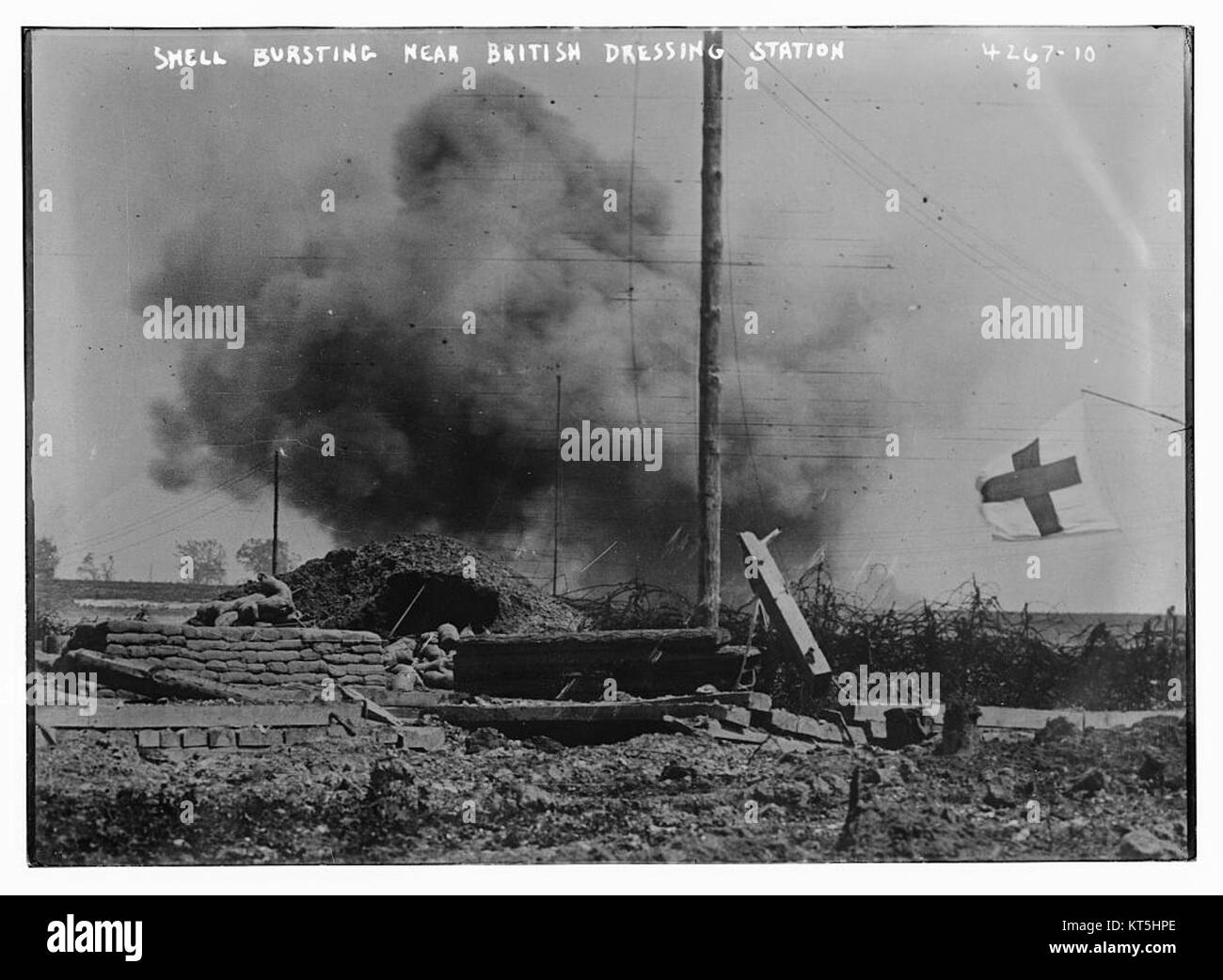 Questa immagine mostra una conchiglia scoppiata vicino a una stazione di vestizione britannica, raffigurante le condizioni intense durante le operazioni militari, probabilmente della prima o della seconda guerra mondiale, mostrando le dure realtà della guerra. Foto Stock