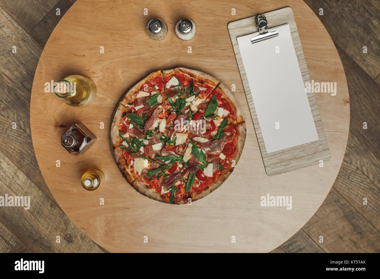 Vista superiore della disposizione della pizza italiana, spezie e vari tipi di olio in bottiglie sul tavolo in legno Foto Stock