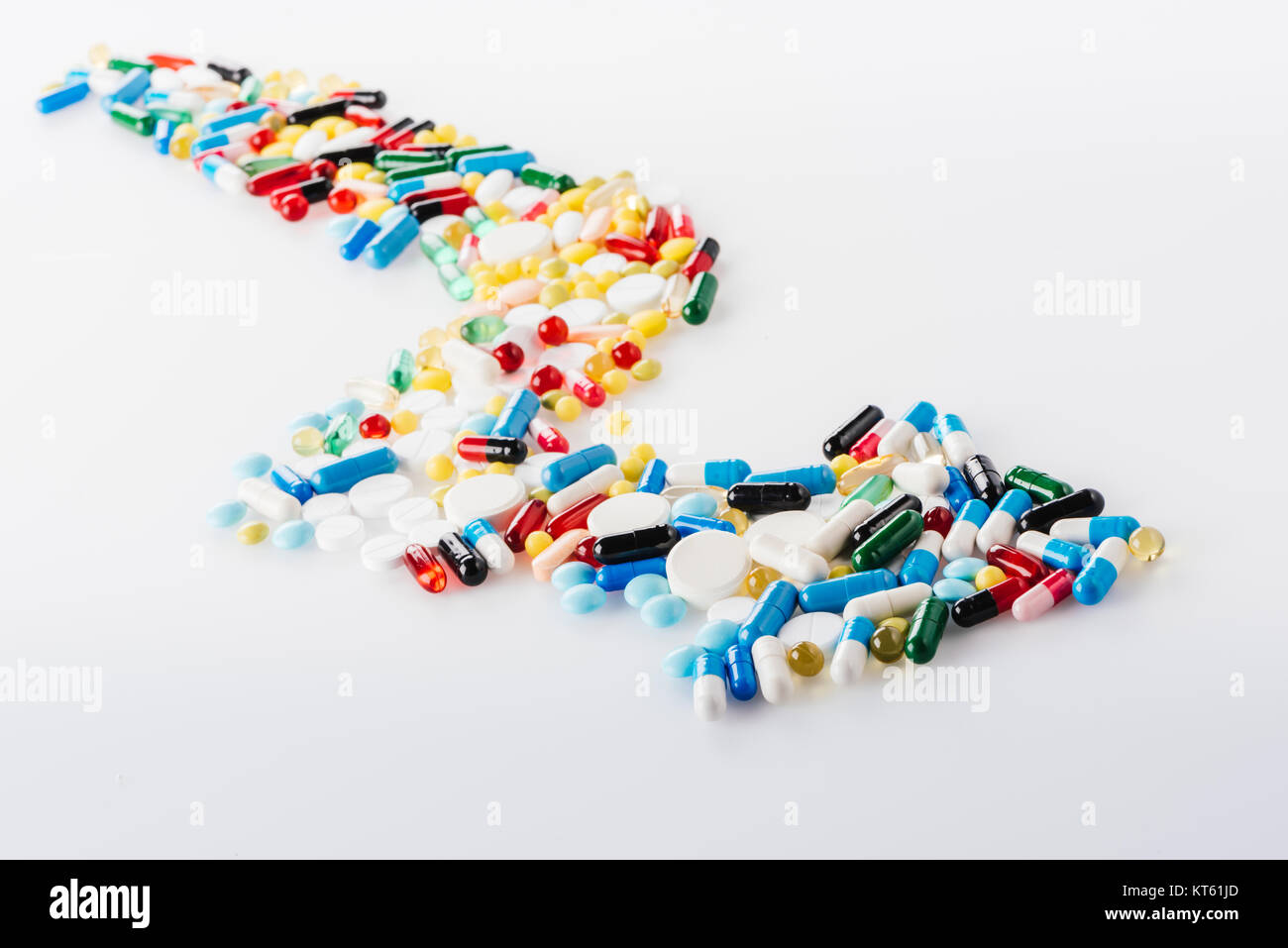 Vista ravvicinata della freccia fatta di pillole di medici su bianco Foto Stock