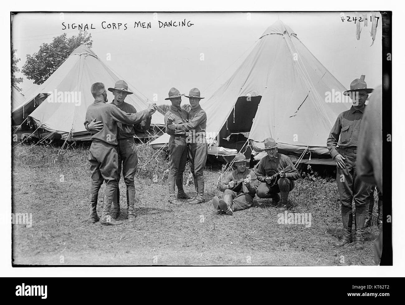 L'immagine del Signal Corps cattura uomini che ballano, forse parte di attività militari o celebrative durante i primi anni del XX secolo, mostrando eventi storici in un contesto sociale. Foto Stock