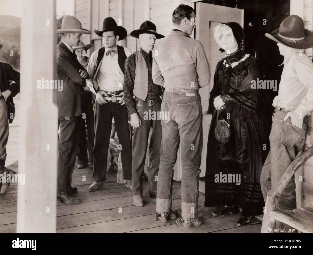Questa fotografia presenta una scena del film del 1934 "The Lucky Texan", con John Wayne. Il film è un dramma occidentale, raffigurante le avventure di un giovane texano che viene coinvolto in una trama pericolosa. Foto Stock