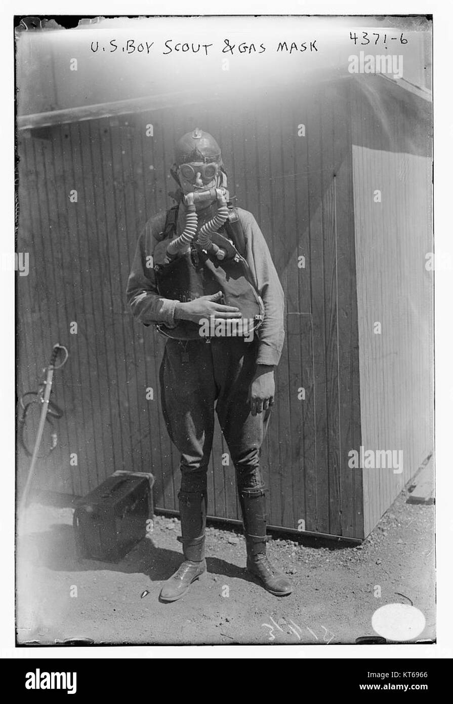 Questa immagine mostra un Boy Scout americano che indossa una maschera antigas, probabilmente durante un evento storico come la seconda guerra mondiale, che riflette il ruolo dei Boy Scout nella difesa civile e nella preparazione durante i periodi di conflitto. Foto Stock