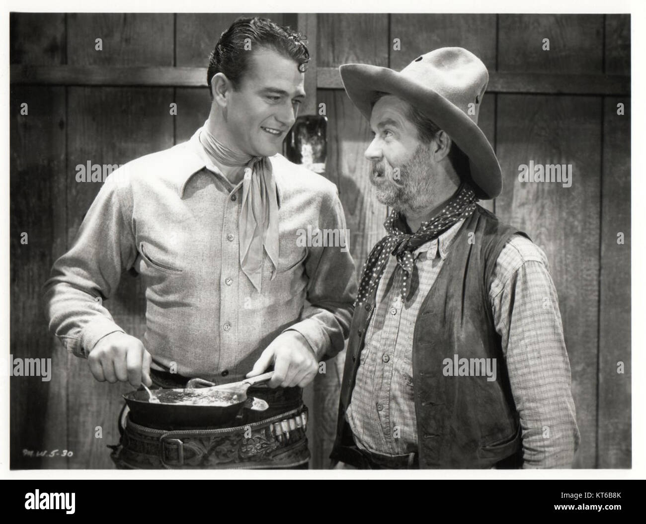 Gli attori John Wayne e George "Gabby" Hayes in una scena da "Blue Steel" (1934), un film WESTERN con Wayne come maresciallo degli Stati Uniti che scopre un piano di cattura di terra. Foto Stock