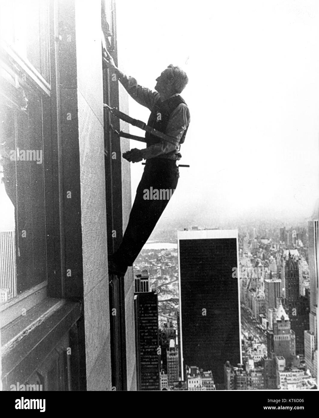 Un detergente per finestre è un individuo specializzato nella pulizia di finestre, spesso su edifici alti o in luoghi difficili da raggiungere. Il lavoro richiede attrezzature di sicurezza e attrezzi specializzati per garantire efficienza e sicurezza durante il lavoro in quota. Foto Stock