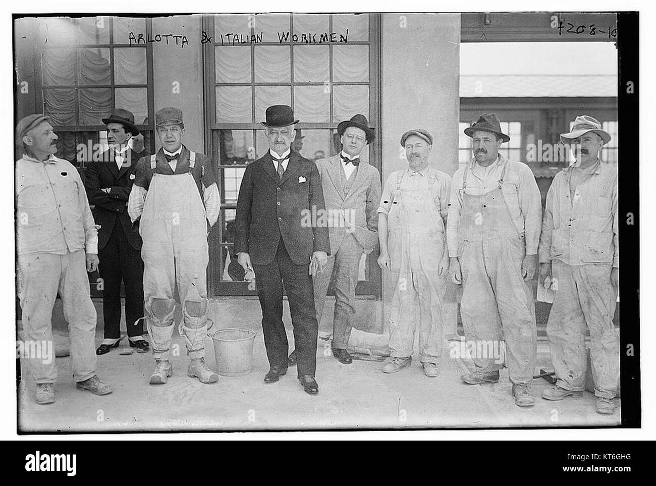 Questa immagine cattura un operaio italiano che collabora con Arlotta, mostrando pratiche di lavoro storiche in Italia. Riflette il rapporto tra manodopera qualificata e artigianato. Foto Stock