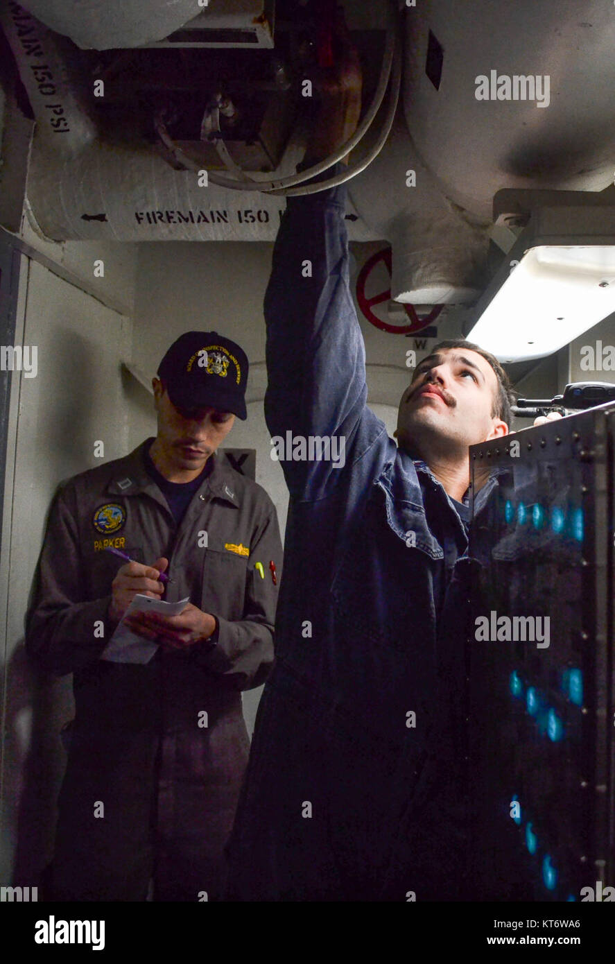 Danni Controlman 3rd Class Brandon Silvia e il tenente Justin Parker, un ispettore dalla scheda di ispezione e di indagine (INSURV), ispezionare le valvole firemain a bordo della USS Cole (DDG 67). Cole è in corso INSURV conduttore, che è un controllo periodico per assicurarsi che la nave soddisfi gli standard della Marina. (U.S. Navy Foto Stock