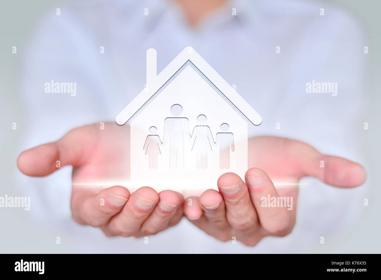 L'uomo d'affari tiene l'icona della casa e il disegno creativo di concetto della proprietà del carattere. Foto Stock