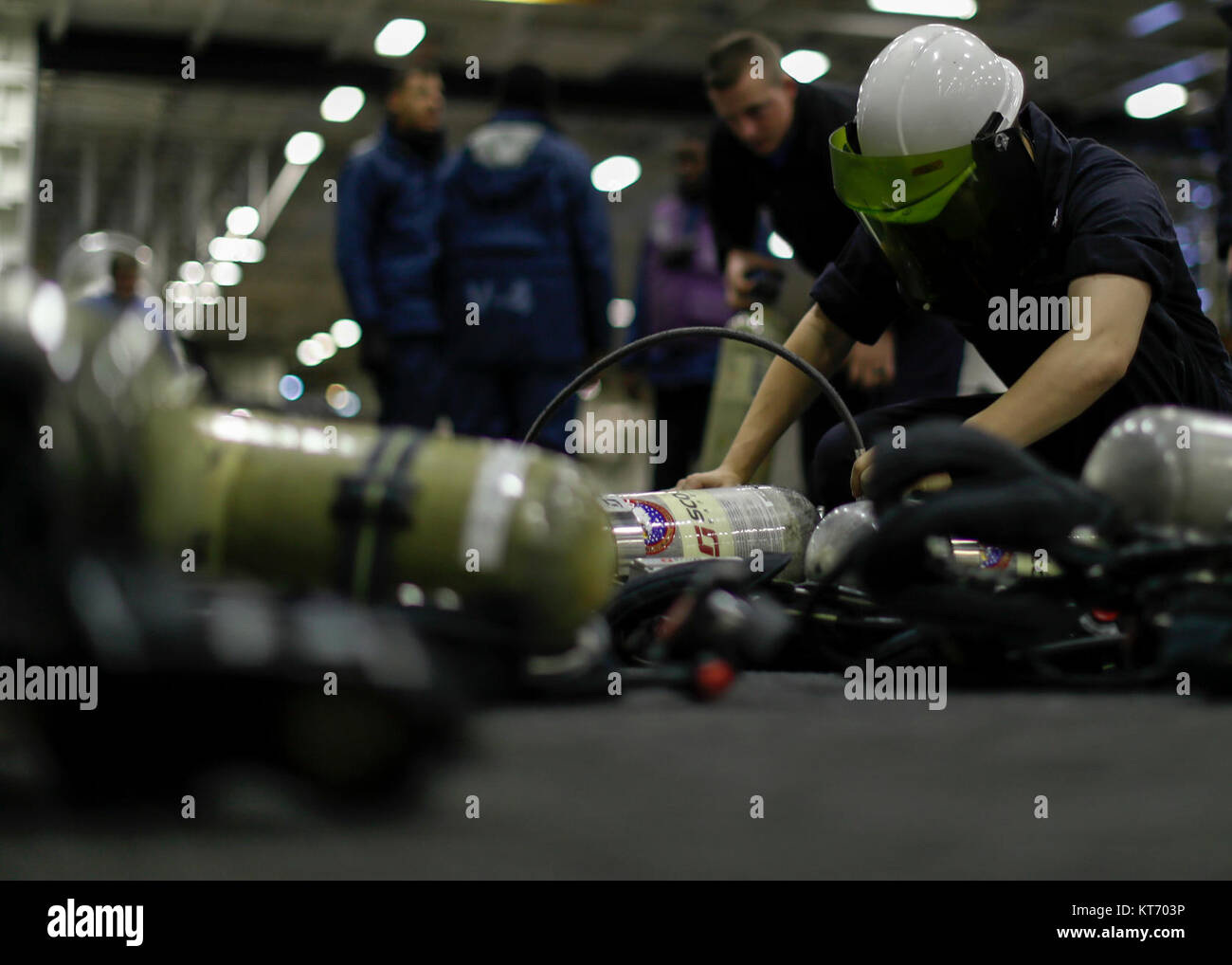 Danni Controlman 3rd Class Britton Raven ricariche autorespiratore serbatoi usati per la lotta antincendio nell'hangar bay a bordo della Nimitz-class portaerei USS Abraham Lincoln (CVN 72). (U.S. Navy Foto Stock