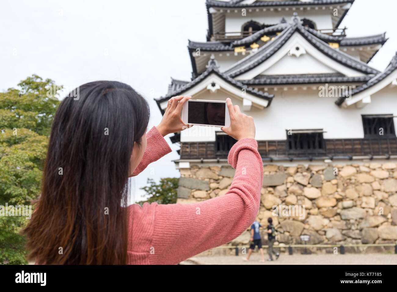 Torna vista posteriore della donna prendendo foto sul castello di Hikone Foto Stock