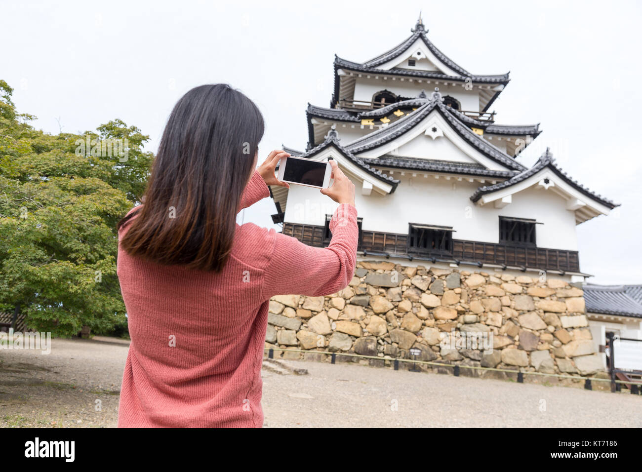 Donna prendendo foto con il telefono cellulare sul castello di Hikone Foto Stock