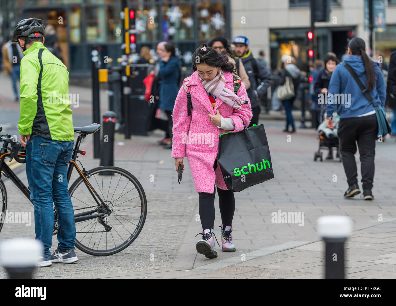 Giovane donna asiatica vestita in costosi cercando vestiti in inverno, nella vivace città di Brighton, East Sussex, Inghilterra, Regno Unito. Foto Stock