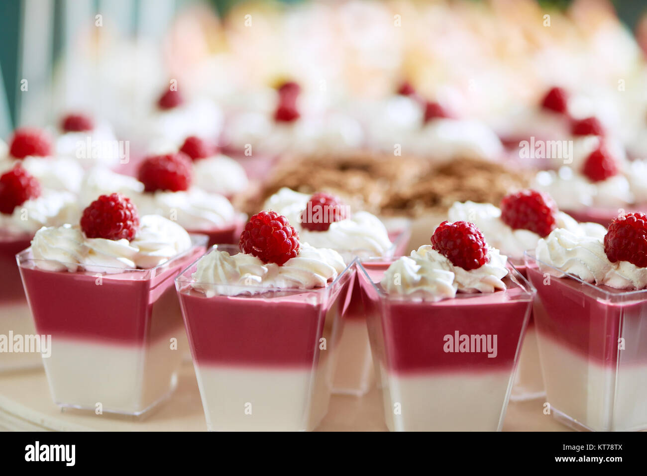 Set di deliziosi dessert : due-strato bianco e rosa souffle,decorate con lamponi freschi e morbida panna montata per un catering rstaurant . Foto Stock