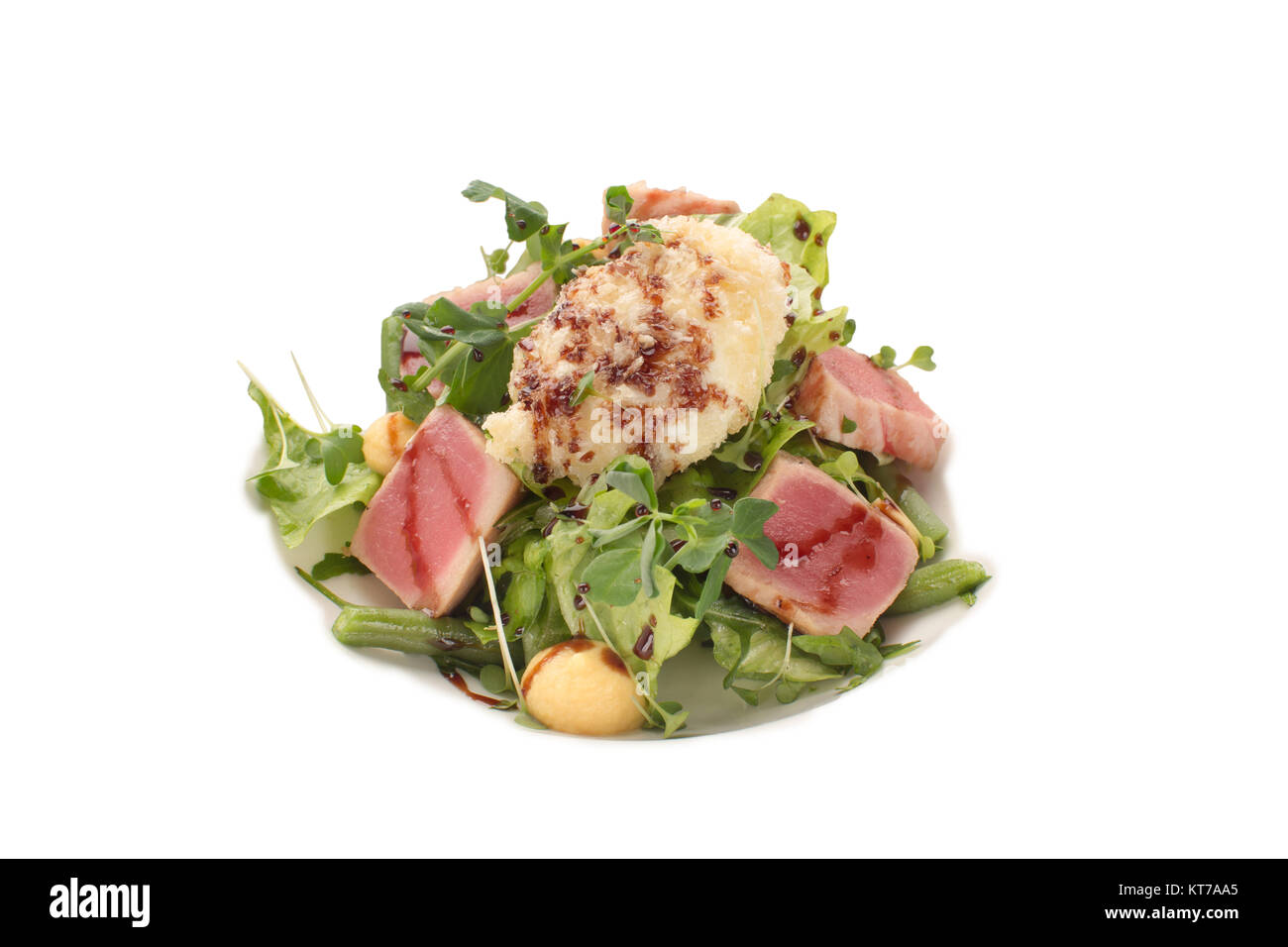 Una squisita insalata di tonno, verdi e fagioli verdi con aceto balsamico su un sfondo isolato Foto Stock