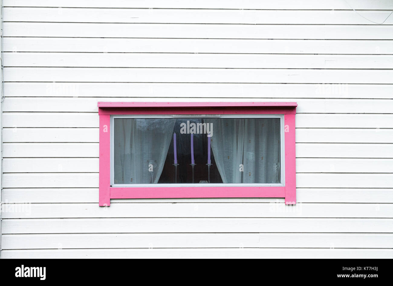 Legno bianco parete finestra rosa tenda tre candele Foto Stock