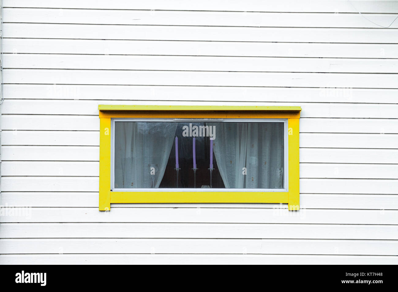 Legno bianco parete finestra giallo tenda tre candele Foto Stock